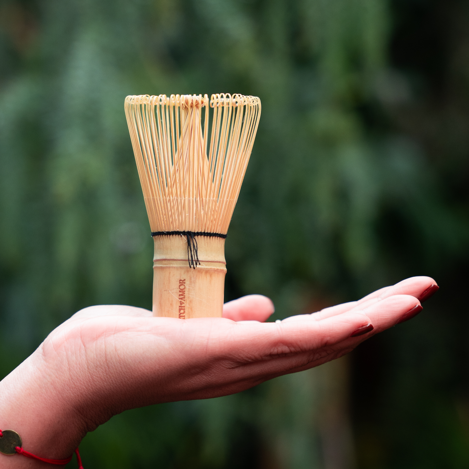 Batidor chasen de bambú para preparación tradicional de matcha sobre una maono